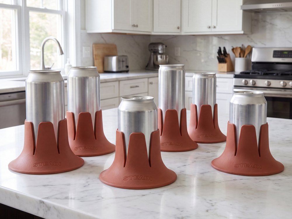 Six Steadis in a row on a kitchen counter, each holding a different can.